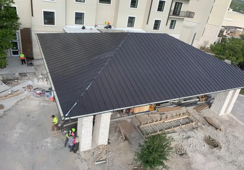 Metal roofing installation team working on a commercial building in Woodside
